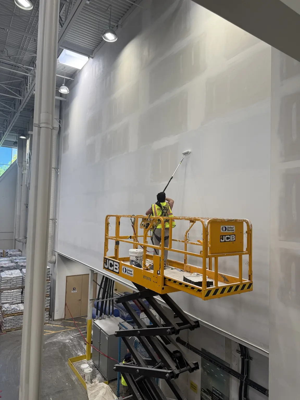 Commercial painter using a mobile elevated work platform at the MAPEI project in Delta, BC