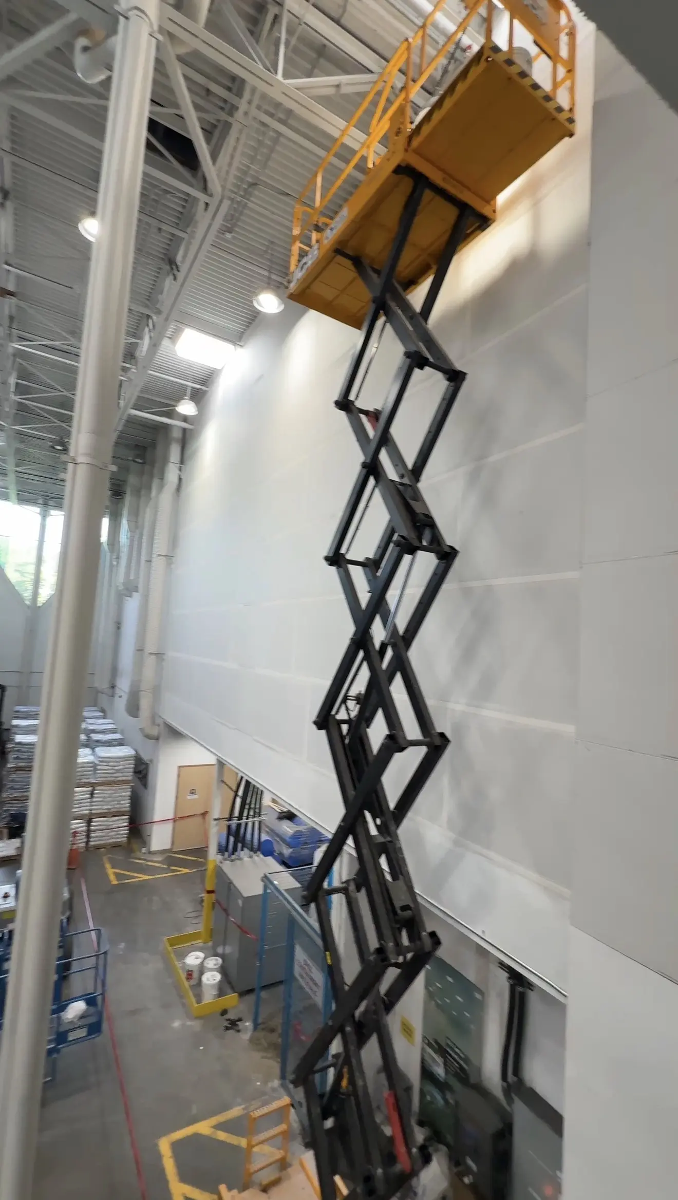 Scissor lift used for elevated work on a high interior wall at the MAPEI project in Delta, BC.